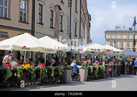 Persone mangiare fuori nella Piazza della Città Vecchia, Cracovia in Polonia. Foto Stock