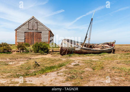 Vista del vecchio capannone di carbone e la vecchia barca di legno a thornham porto sulla Costa North Norfolk Foto Stock