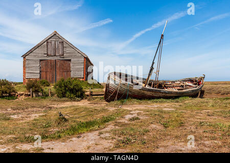 Vista del vecchio capannone di carbone e la vecchia barca di legno a thornham porto sulla Costa North Norfolk Foto Stock