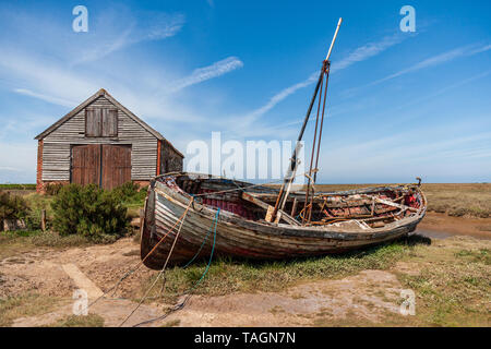 Vista del vecchio capannone di carbone e la vecchia barca di legno a thornham porto sulla Costa North Norfolk Foto Stock