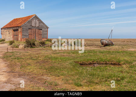 Vista del vecchio capannone di carbone e la vecchia barca di legno a thornham porto sulla Costa North Norfolk Foto Stock