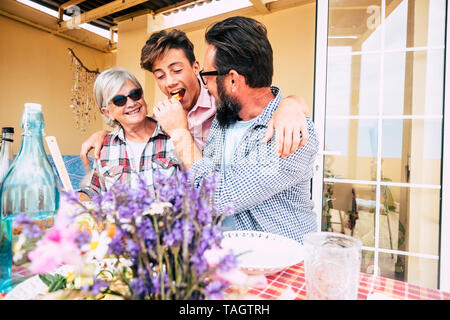 Tre diverse generazioni della famiglia popolazione caucasica ocncept mangiare pranzo insieme - nonna, figlio e nipote hanno fon con amore e amicizia outd Foto Stock