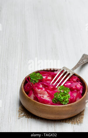 Con insalata di cavolo e barbabietola in ciotola di legno sul tavolo bianco Foto Stock