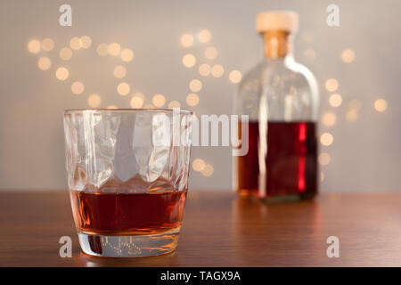 Whiskey splash in vetro su un tavolo di legno. Foto Stock