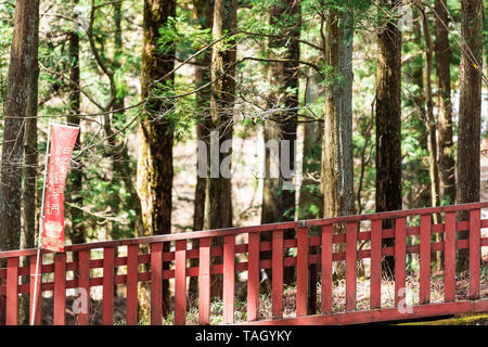 Nikko, Giappone - Aprile 5, 2019: Tempio Toshogu ringhiera rossa con segno nella Prefettura di Tochigi durante la primavera closeup di architettura di dettaglio e gli alberi per Foto Stock