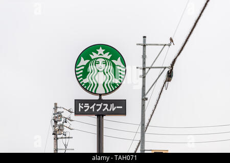 Takayama, Giappone - Aprile 6, 2019: Prefettura di Gifu in Giappone con il segno in giapponese per Starbucks Coffee shop isolato contro il cielo nuvoloso giorno Foto Stock