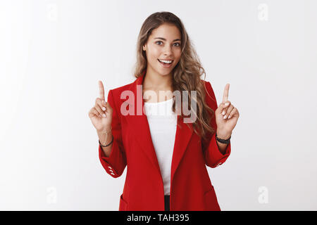 Ambizioso bella donna sta preparando un lavoro importante presentazione office sollevando le dita indice mostrando copia superiore spazio ampiamente sorridente Foto Stock