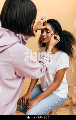 Trucco artisti applicando degli occhi fino al modello in studio Foto Stock