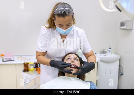 Dentiera parziale, donna matura paziente seduto in poltrona odontoiatrica, medico dentista facendo protesi dentale. Sanitario, medico e concetto di odontoiatria Foto Stock