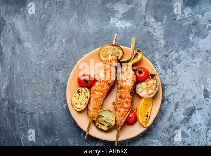 Grigliate di pesce Salmone alla griglia con aggiunta di succo di limone.piatto di salmone alla griglia bistecca Foto Stock