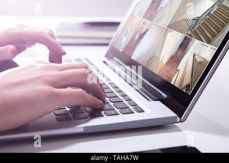 Close-up di un imprenditore il monitoraggio a mano telecamera TVCC filmati sul computer portatile Foto Stock