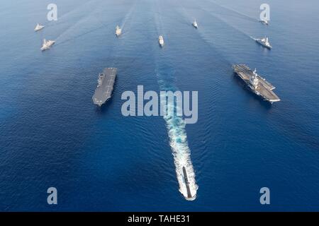 La Marina australiana sommergibile HMAS Collins conduce una multinazionale di formazione tra cui la marina francese portaerei FS Charles de Gaulle, destra e marina giapponese elicottero destroyer JS Izumo, sinistra, durante la fase di esercizio La Perouse Maggio 22, 2019 nella baia del Bengala. Foto Stock