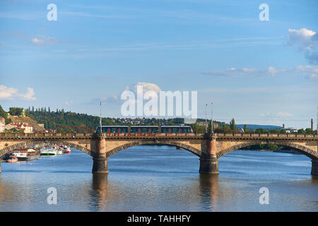 Praga, Repubblica Ceca - 3 Luglio 2017: moderno tram attraversando ponte sul fiume Moldava a Praga il sunny luglio serata. Foto Stock