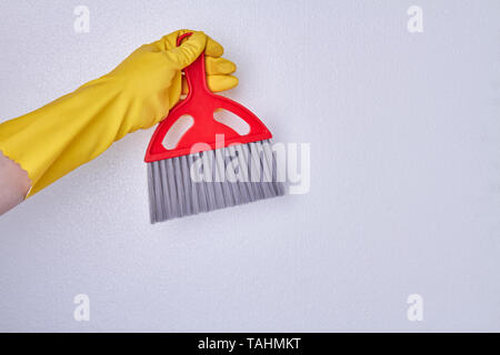 Mano con guanto di pulizia di contenimento scopa. Persona in guanto di gomma rosso di contenimento della spazzola di pulizia . Spazio per il testo. Foto Stock