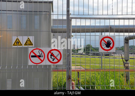 Fabbrica. Segno infiammabile sulla recinzione di un impianto industriale Foto Stock