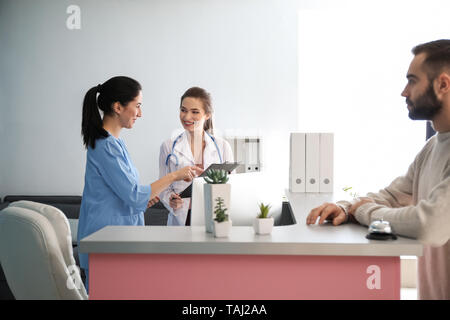 Paziente in attesa presso la reception in clinica Foto Stock