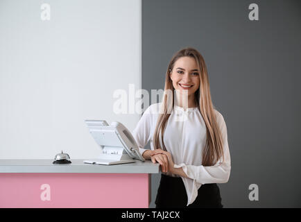 Receptionist femmina vicino alla scrivania in hotel Foto Stock