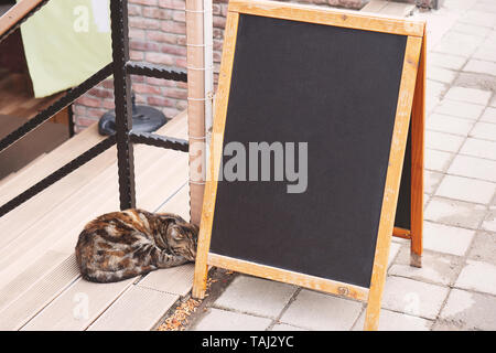 Menu vuoto stand e cat on cafe esterno sfondo, mock up Foto Stock