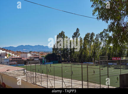 I giovani della scuola i bambini facendo formazione di calcio su un tutti meteo passo sulla periferia di Malaga città in Andalusia, Spagna. Foto Stock