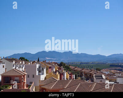 Che si affacciano sui tetti delle nuove case a schiera costruito alla periferia della città di paese di Pizara in Andalucia, vicino a Malaga, Spagna. Foto Stock