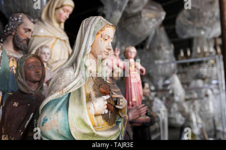 Scartato Cattolica Romana statuette cristiana memorizzati in un capannone Foto Stock