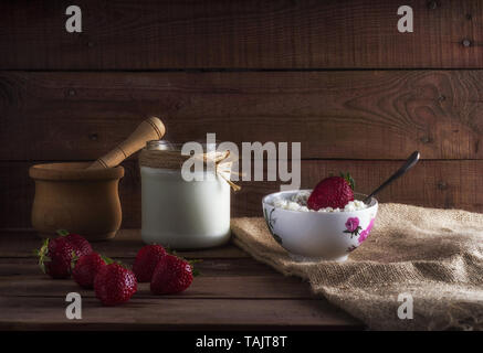 Tvorog, agricoltori, formaggio di ricotta o formaggio nella ciotola con freschi frutti di bosco d'estate. Ricca in calcio cibo sano Foto Stock