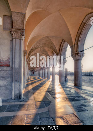 Venezia, Italia - 01/04/2017: mattina sole splende tra colonne architettonica del palazzo ducale Foto Stock