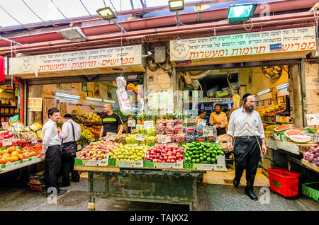 Gerusalemme, Israele- Agosto 16, 2016: una folla di uomini shopping per le verdure in un negozio nel Mahane Yehudah mercato di Gerusalemme, Israele Foto Stock