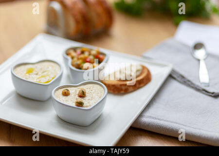 Houmous e ceci insalata snack serviti con pane tostato sul lato. Foto Stock