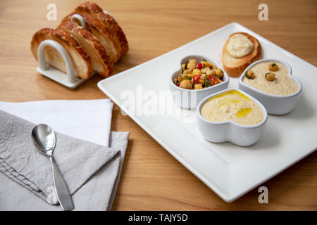 Houmous e ceci insalata snack serviti con pane tostato sul lato. Foto Stock