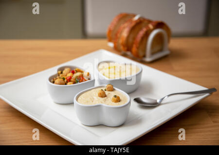 Houmous e ceci insalata snack serviti con pane tostato sul lato. Foto Stock