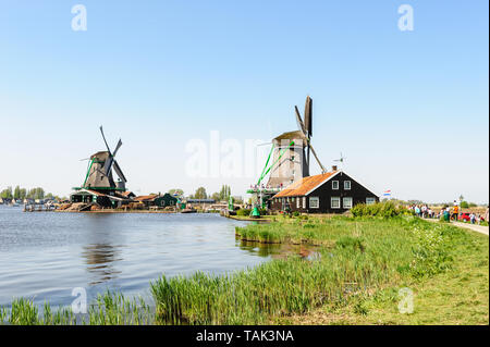 Zaanse Schans, Paesi Bassi - 22 Aprile 2019: turisti sightseeng olandesi tradizionali case rurali e mulini a vento di Zaanse Schans, è una tipica piccola vill Foto Stock