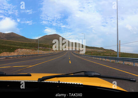 La vista dalla cabina del taxi auto, l'autostrada conduce dalla città di Kayseri al piede del Monte Erciyes nel centro della Turchia. Foto Stock