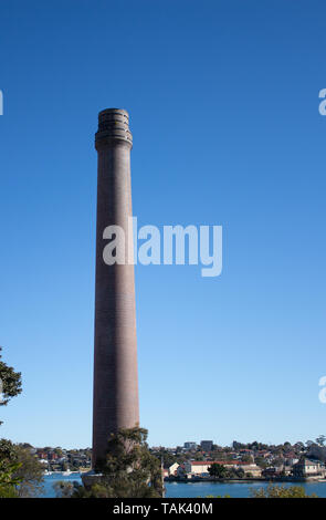 La fabbrica di mattoni stack di fumo contro il cielo blu impostato su Cockatoo Island Porto di Sydney Australia Foto Stock