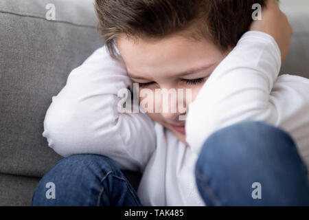 Close up ha sottolineato bambino testa del coperchio segnata da conflitti Foto Stock