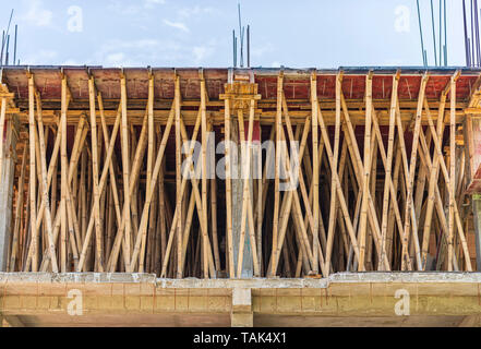 La costruzione di edifici in India. Una impalcatura di bambù essendo utilizzato per il supporto di una nuova colata di cemento armato cemento (RCC) soletta del tetto. Foto Stock