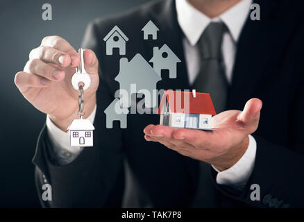 Agente immobiliare azienda chiave di casa un modello di casa Foto Stock