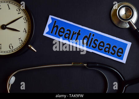 La malattia di cuore sulla carta di stampa con il concetto di assistenza sanitaria ispirazione. sveglia, nero stetoscopio. Foto Stock