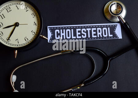 Colesterolo su carta con il concetto di assistenza sanitaria ispirazione. sveglia, nero stetoscopio. Foto Stock