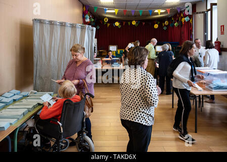 Le persone sono considerate la compilazione di loro schede elettorali in corrispondenza di una stazione di polling spagnolo durante il locale, regionale ed elezioni del Parlamento europeo a Madrid. Foto Stock