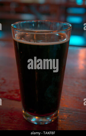 Il vetro di una Birra stout su una tavola di legno in un bar Foto Stock