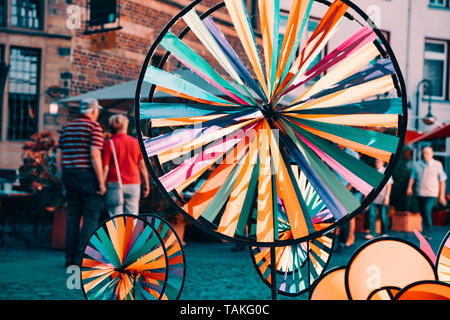 Colorato whirligigs contrastante con lo sfondo di una strada dello shopping di Xanten Foto Stock