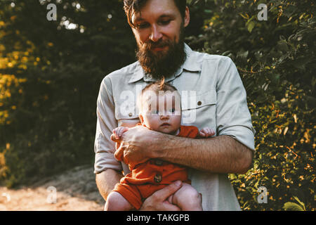 Padre con il bambino a piedi nella foresta insieme viaggi in famiglia lifestyle papà tenendo la paternità del bambino amore emozioni concetto Foto Stock