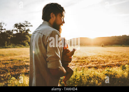 Padre e baby camminare insieme all'aperto lo stile di vita della famiglia papà viaggiare con bambino genitorialità padri giorno concept Foto Stock