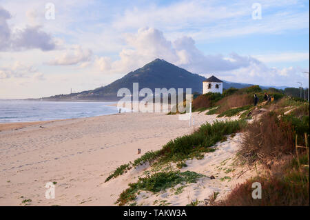 Spiaggia di moledo alla fine della giornata, con vista montagna trega sul lato spagnolo del confine. La bassa marea visualizzando la spiaggia sabbiosa su una torbida da Foto Stock