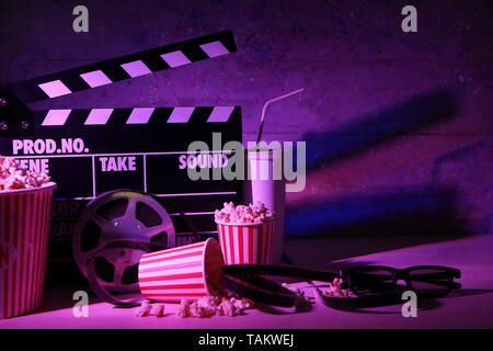 Filmato battaglio con bobina di film e popcorn sul tavolo Foto Stock