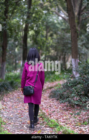 Una giovane ragazza camminare nella foresta, Lonely ragazza adolescente nel giardino botanico, Wuhan Hubei , Cina. Foto Stock