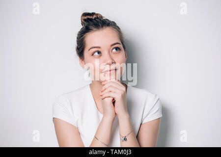 Sorridenti donna guarda in alto, mette le mani insieme nella preghiera, si sente grato, le speranze per il successo della realizzazione del piano, crede nel successo aziendale, desiderio Foto Stock