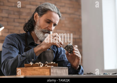 Gioielliere rendendo splendida bracciale in officina Foto Stock