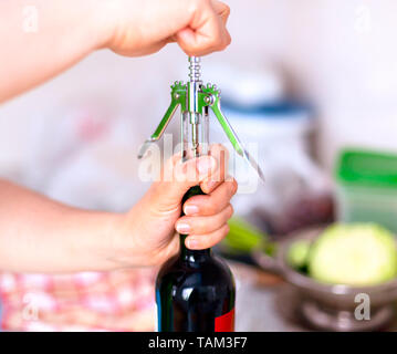 Donna di aprire una bottiglia di vino con un cavatappi. Close-up Foto stock  - Alamy